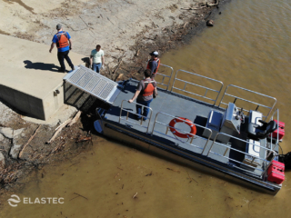 Platform utility workboat with landing ramp docked